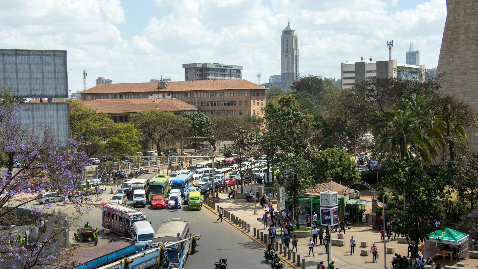 A view over central Nairobi with matatus queued along a main road and office towers behind